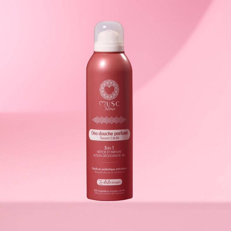 Gros plan du flacon aérosol rose Musc Intime 945233 Sweet Litchi sur fond rose doux, mettant en vale