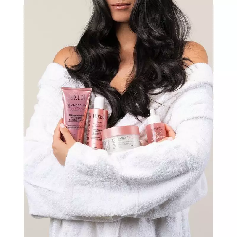 Produits Luxéol Brillance disposés : tube shampoing, pochette rose, pot masque, sérum soin, pipette 