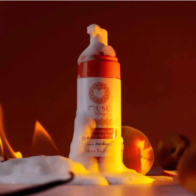 Gros plan de la mousse nettoyante intime Hot Peach de Musc Intime, montrant sa texture légère et aér