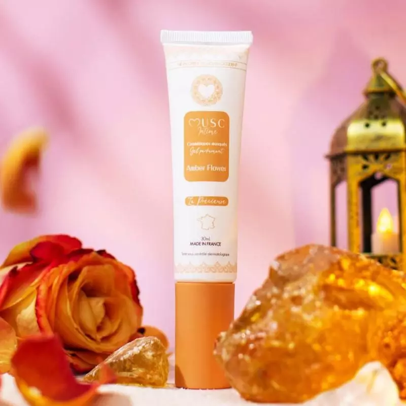 Plan d'ambiance du gel parfumé Musc Intime Fleur d'Ambre posé sur une surface en bois avec des pétal