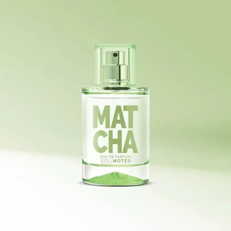 Flacon de Solinotes Eau de Parfum Thé Matcha - 50ml posé sur une table en bois, entouré de feuilles 