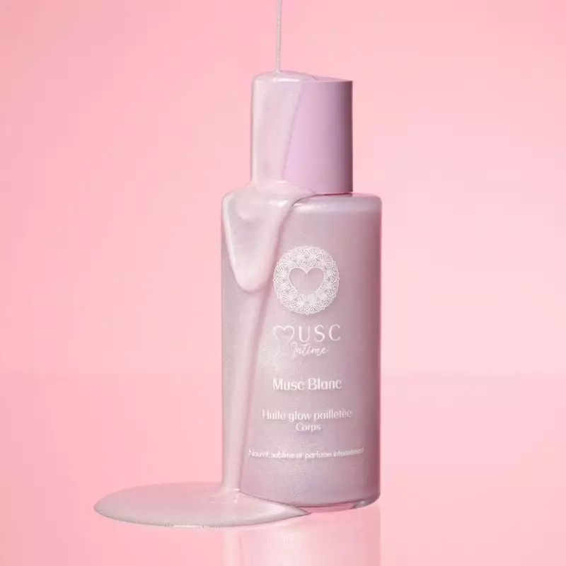 Modèle appliquant l'huile Glow scintillante 1985874, mettant en valeur une peau douce et souple.