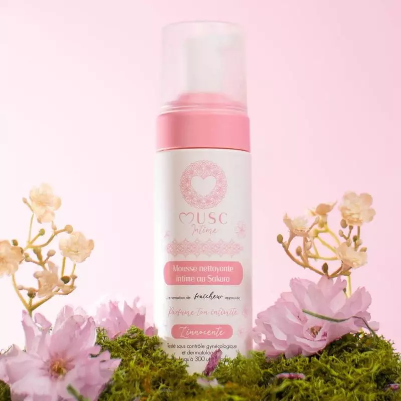 Mousse nettoyante intime Musc Intime Sakura dans une salle de bain sereine avec des fleurs de cerisi