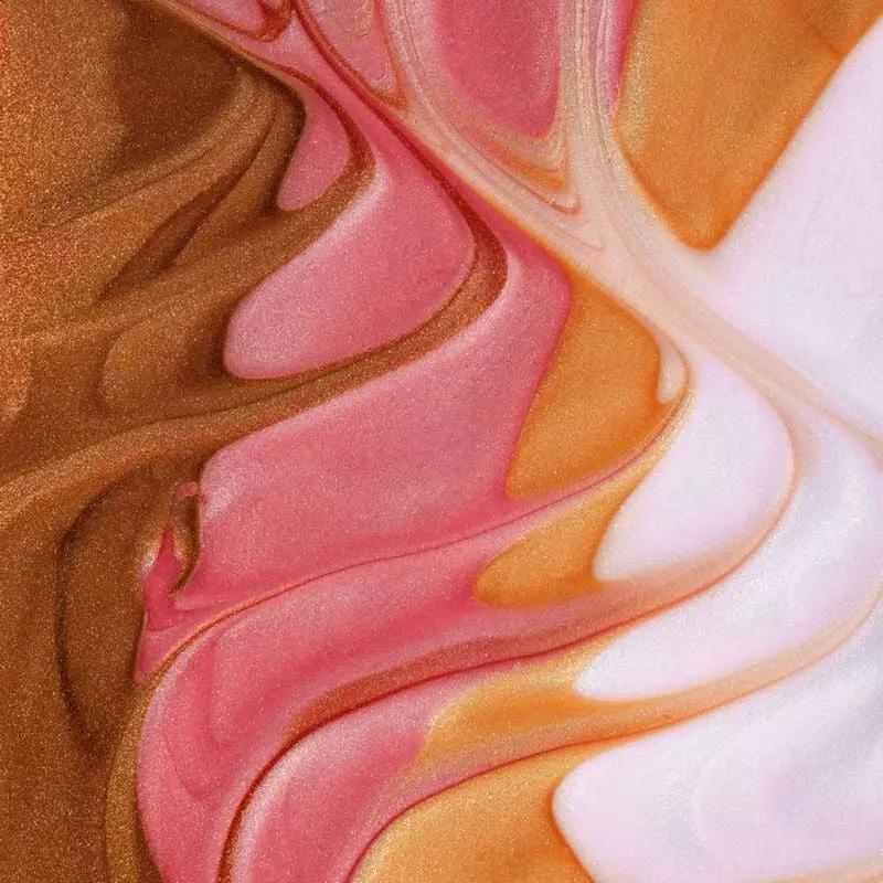 Gros plan de l'huile corporelle Glow 1985863 de Musc Intime montrant des particules de nacre dorée e