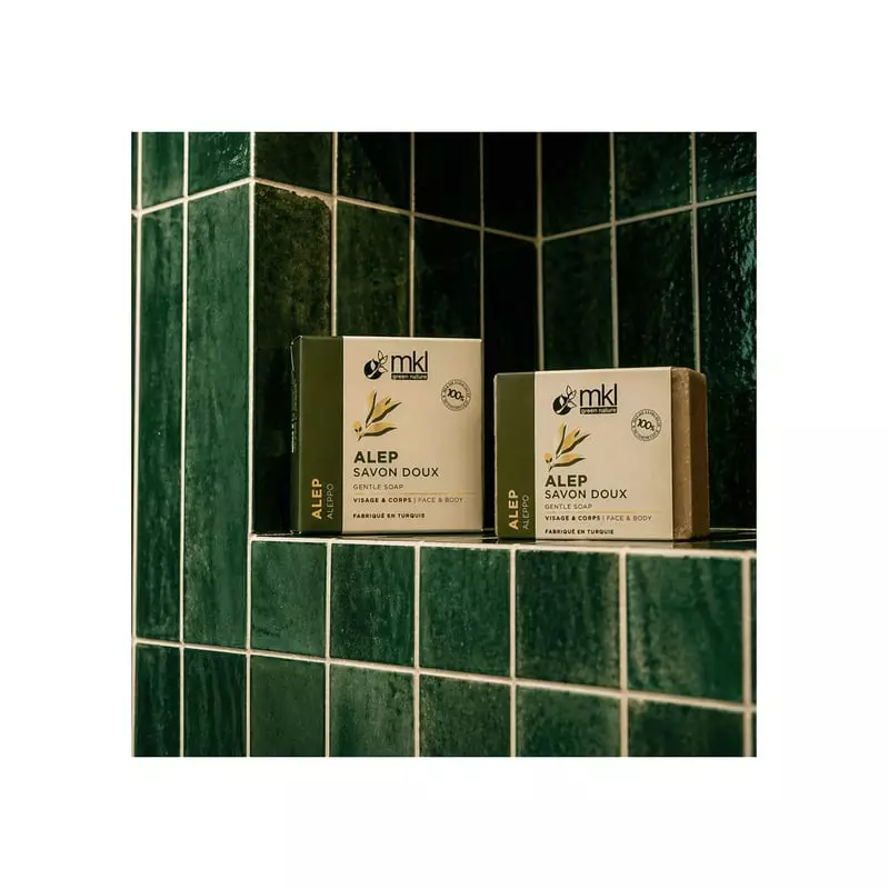 Image d'ambiance lifestyle montrant un savon d'Alep avec des branches d'olivier et de laurier