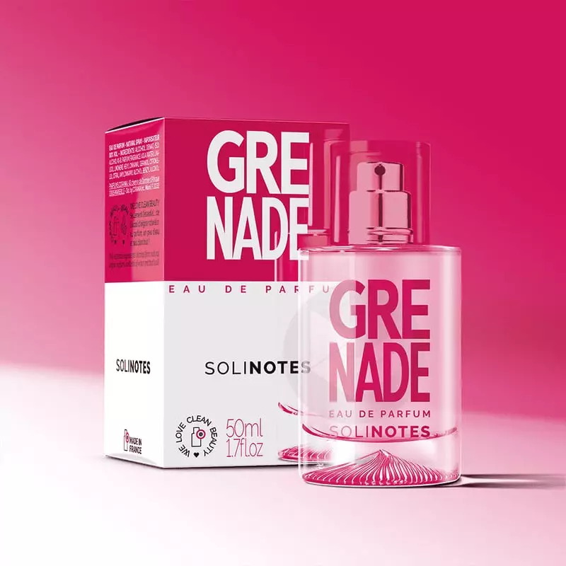 Photo lifestyle du Parfum Grenade Solinotes entouré de grenades fraîches et de fruits d'été, évoquan