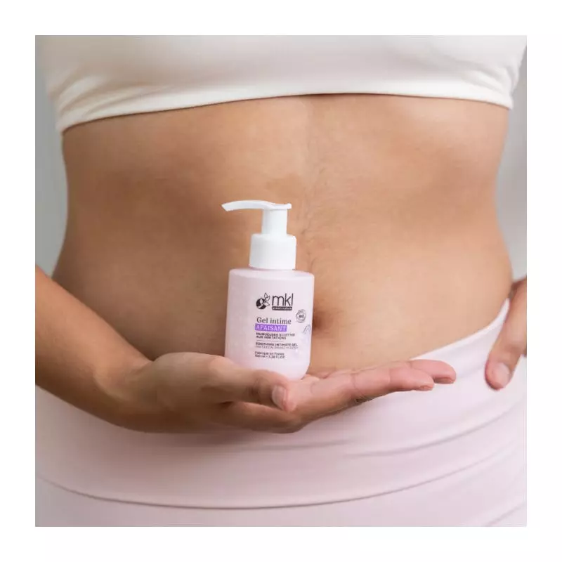 Flacon pompe MKL Gel Intime Apaisant 100ml dans une ambiance spa apaisante, entouré d'extraits bio d