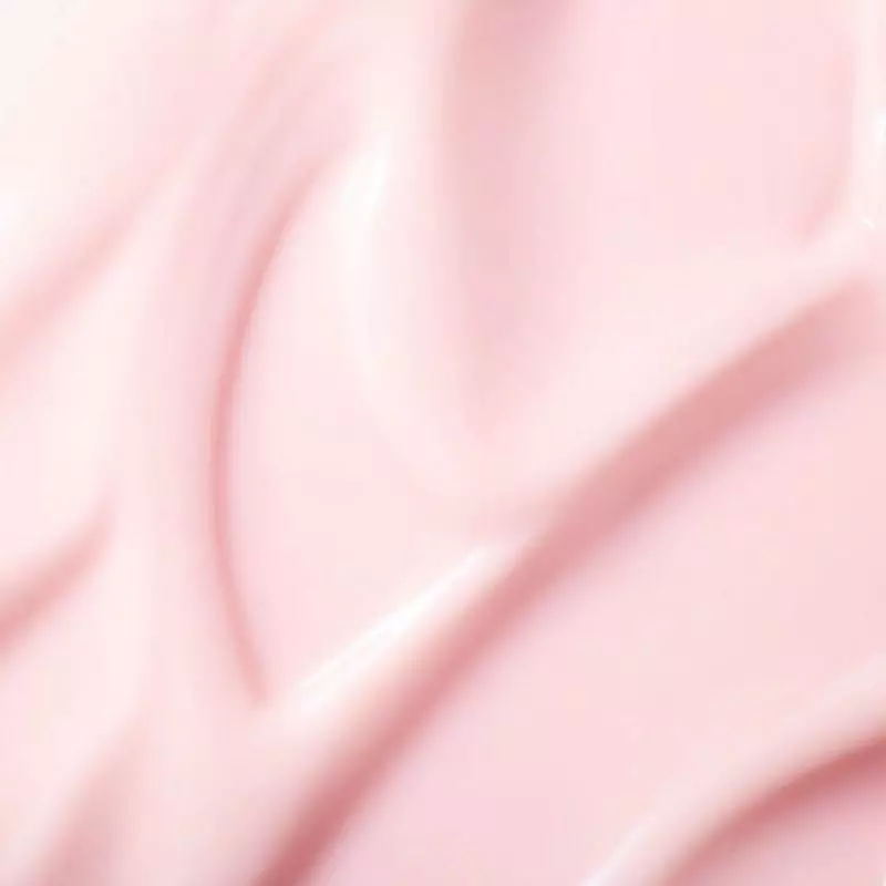 Gros plan sur la texture gel-crème rose lisse et brillante de NUXE Prodigieuse Hyalu Boost, révélant