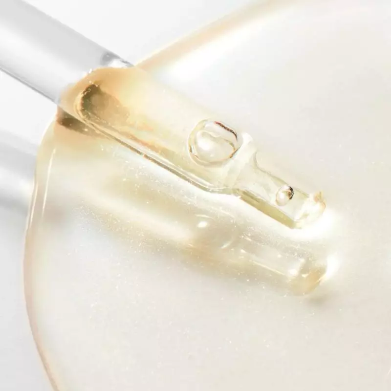 Gros plan sur goutte de sérum doré sur pipette du Sérum Éclat Hyalu-Boost Prodigieuse Nuxe, texture 