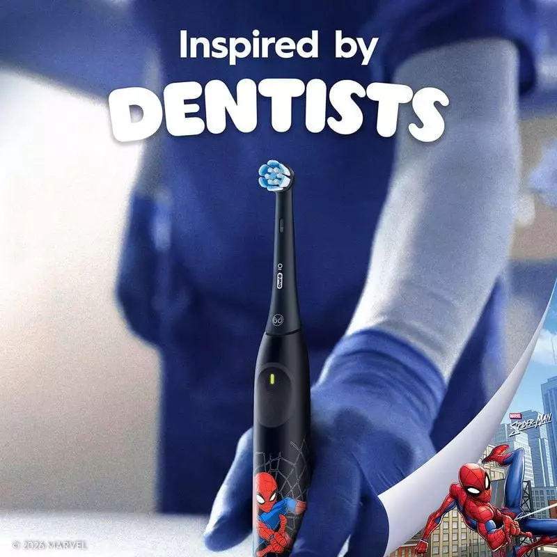 Mains tenant la brosse à dents électrique Oral-B iO Kids Spiderman, inspirée des dentistes, fond vil