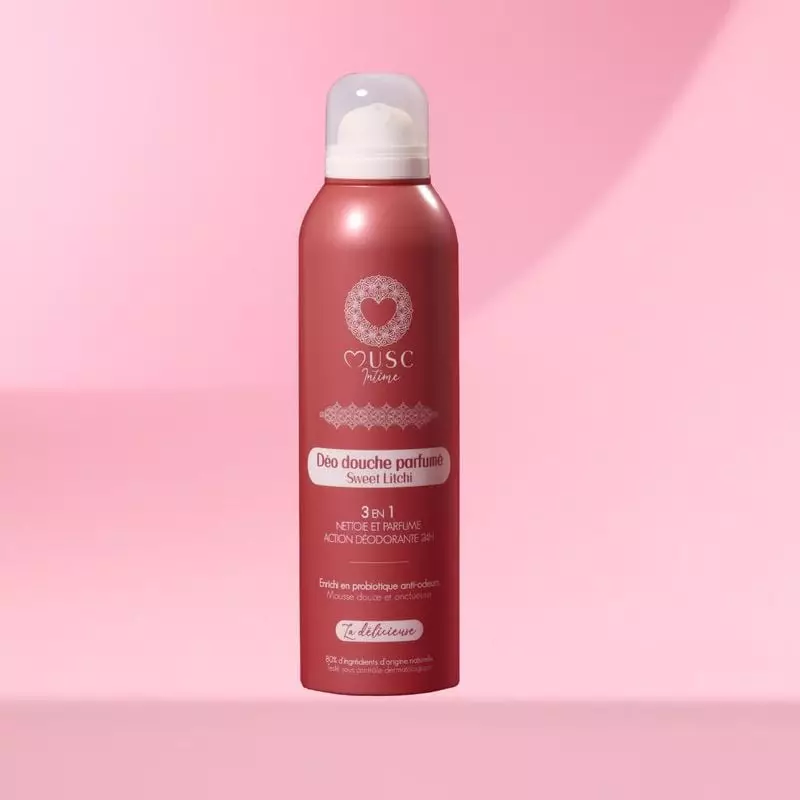 Gros plan du flacon aérosol rose Musc Intime 945233 Sweet Litchi sur fond rose doux, mettant en vale