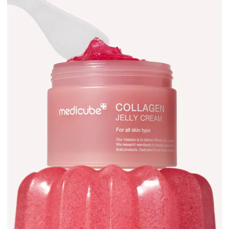 Scène ambient du pot de Crème Jelly au Collagène MEDICUBE avec gel rose appliqué à la spatule, sur b