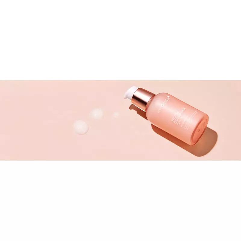 Flacon MEDICUBE Sérum Triple Collagène 4.0 avec gouttelettes de sérum sur surface rose clair.