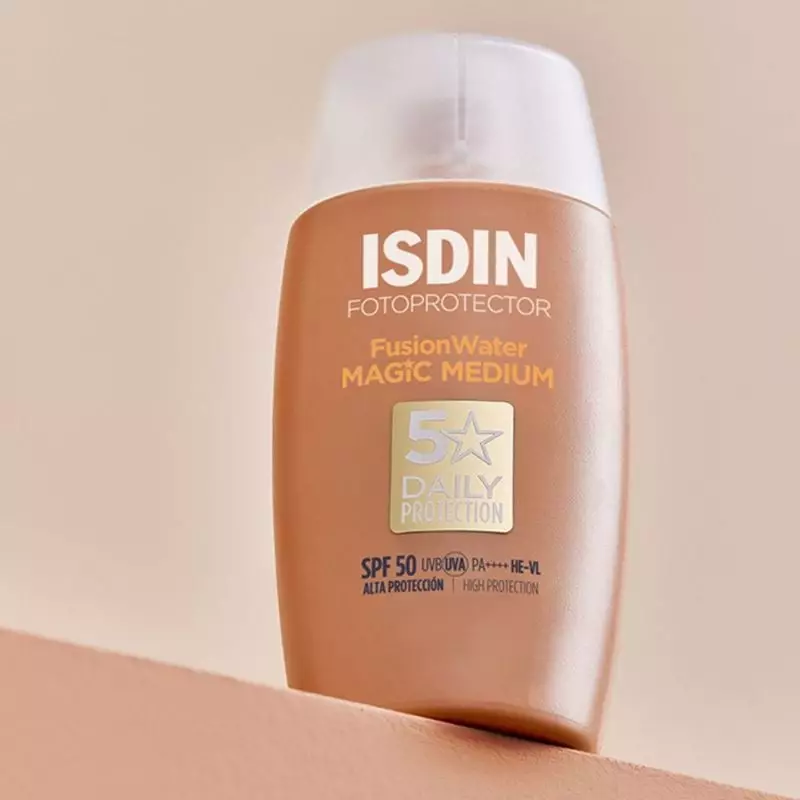 Gros plan du tube ISDIN Fusion Water Magic Medium SPF50 sur surface inclinée, mettant en avant la ma