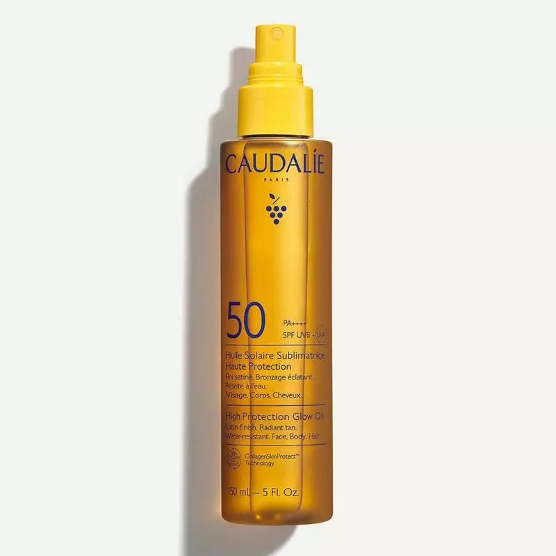 Caudalie Huile Solaire Sublimatrice SPF50+ vue avant : flacon spray jaune avec huile ambrée, logo ma