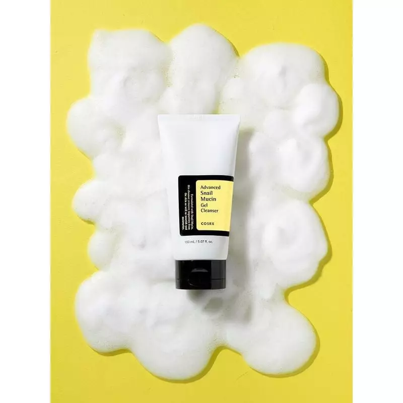 Tube COSRX Nettoyant Gel à la Mucine d'Escargot Avancé debout avec mousse blanche autour sur fond ja