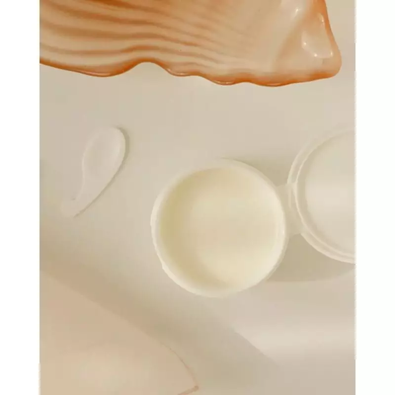 Beauty of Joseon Baume Démaquillant Radiance, pot ouvert avec produit crémeux et spatule sur fond co