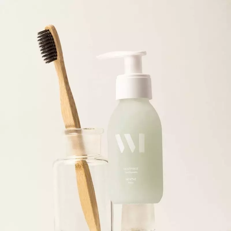 Dentifrice menthe What Matters en flacon verre avec brosse bambou dans support verre, fond beige min