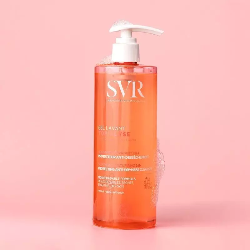SVR Topialyse Gel Lavant Doux 400ml flacon pompe avec mousse et bulles sur fond rose.