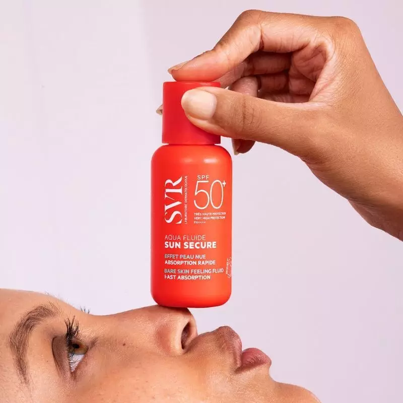 Gros plan sur SVR SUN SECURE Aqua Fluide SPF50+ appliqué sur la peau.