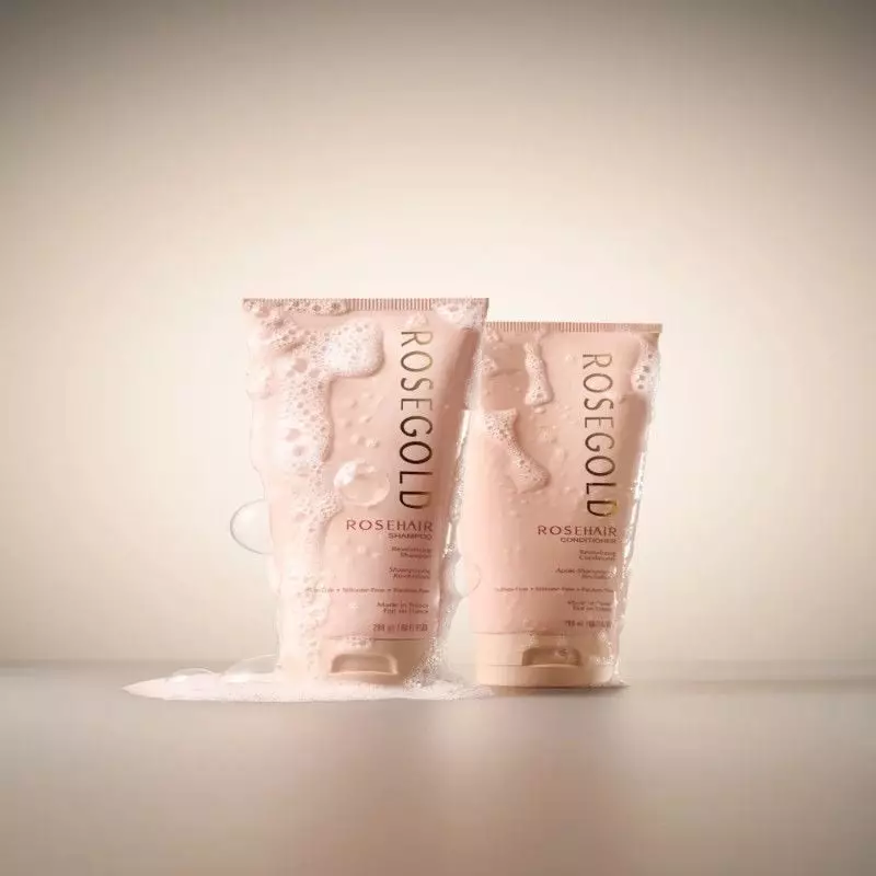 Flacon d'après-shampoing Rosegold Rosehair posé sur une surface en bois avec lumière naturelle.