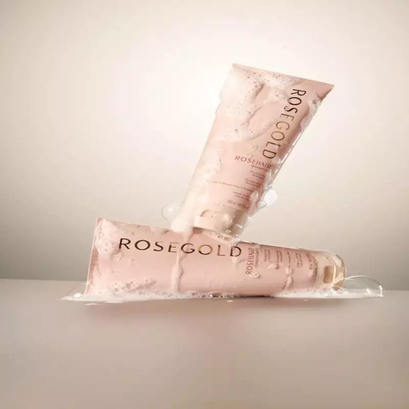 Gros plan du flacon d'après-shampoing Rosegold à la kératine avec un arrière-plan flou.