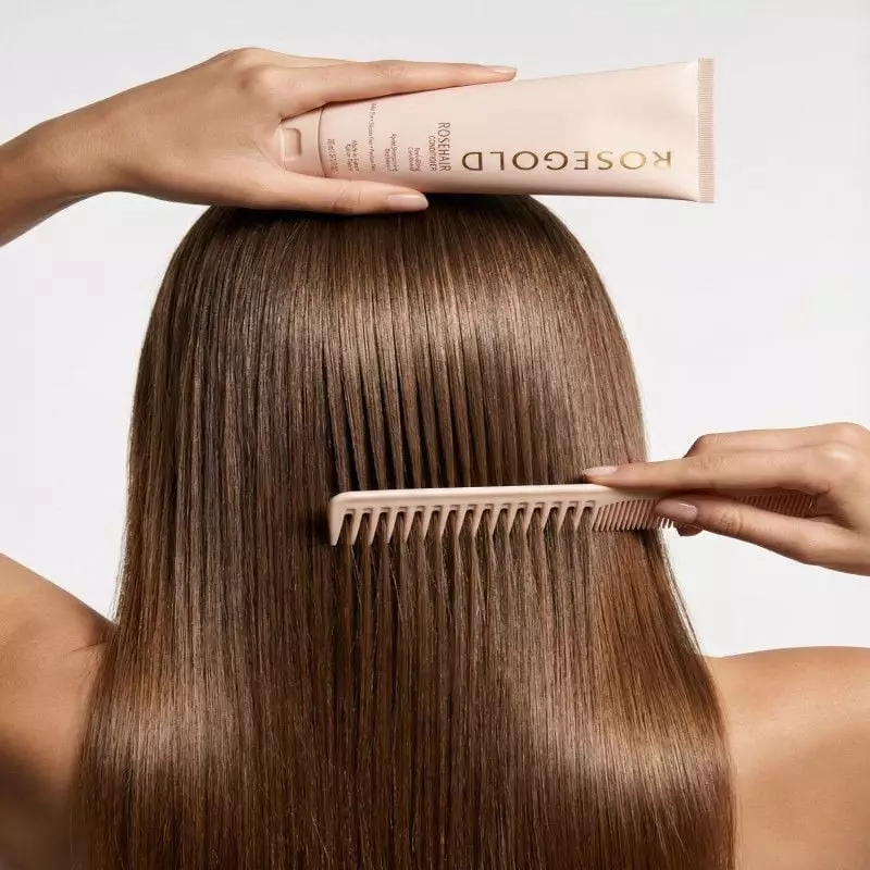 Femme aux cheveux brillants et sains utilisant l'après-shampoing Rosehair de Rosegold dans une scène