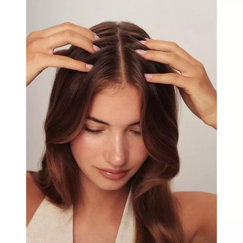 Une femme appliquant le shampoing Rosegold sous la douche, avec de la mousse visible dans ses cheveu