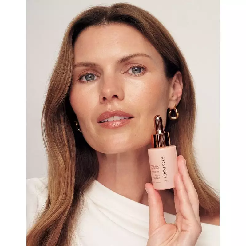 Une femme aux cheveux brillants et volumineux après avoir utilisé le Rituel capillaire Rosegold, sou