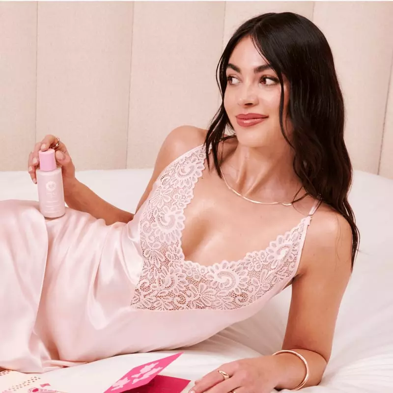Femme appliquant l'Huile Glow Pailletée Musc Blanc sur son bras, montrant l'effet scintillant et lum