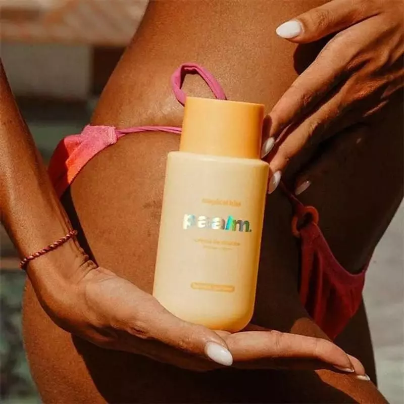 Femme appliquant la crème douche Tropical Kiss de PAALM COSMETICS sous la douche.