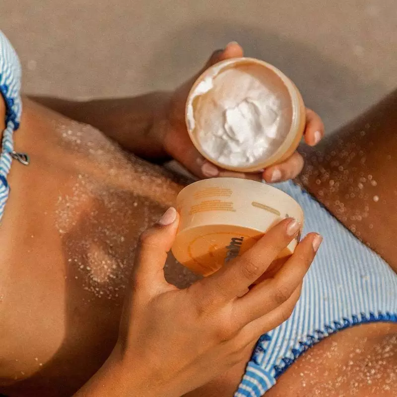 Image lifestyle d'une personne appliquant la crème fouettée corps PAALM 1454441 sur son bras, souria