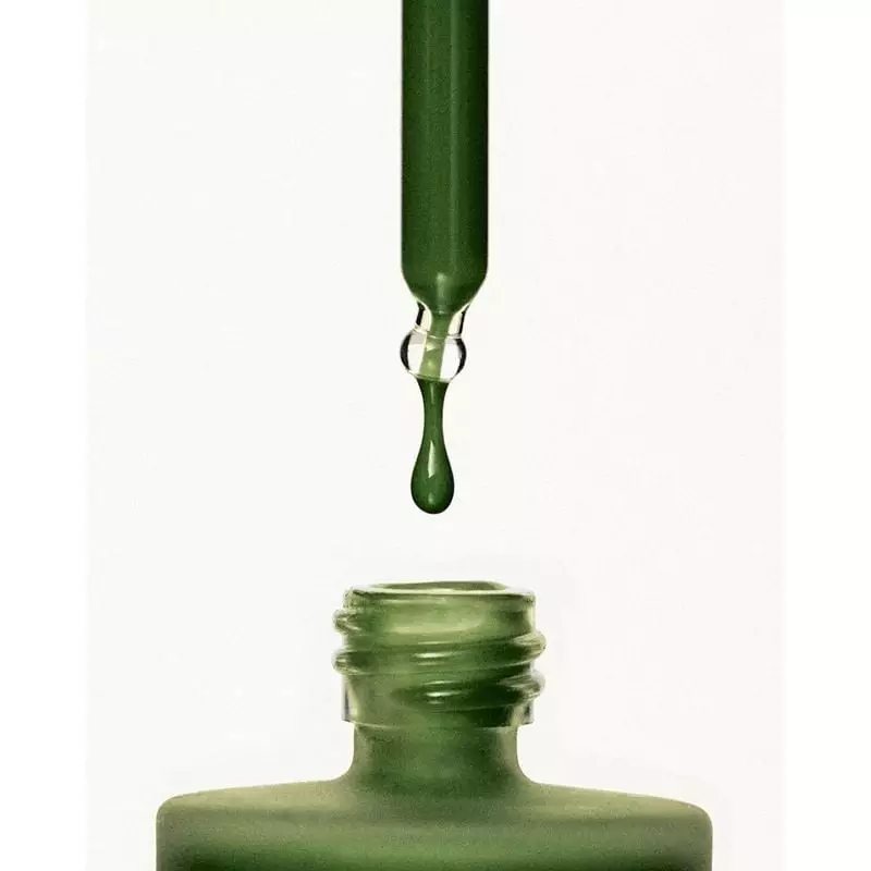 Détail en gros plan du compte-gouttes du sérum purifiant Respire libérant une goutte du sérum fluide
