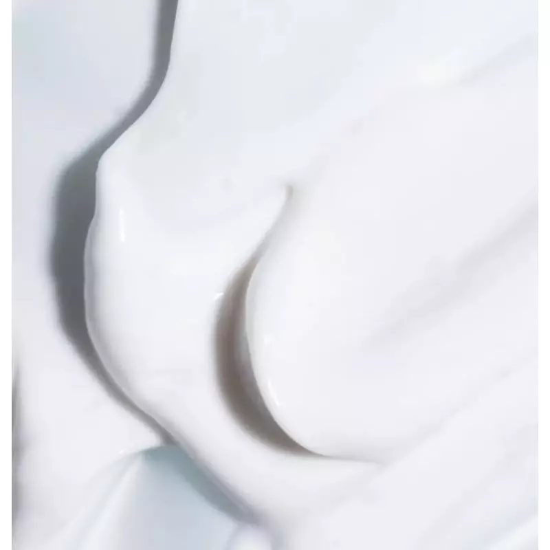 Main prélevant une petite quantité de la Crème Riche Hydratation Intense Respire du pot.