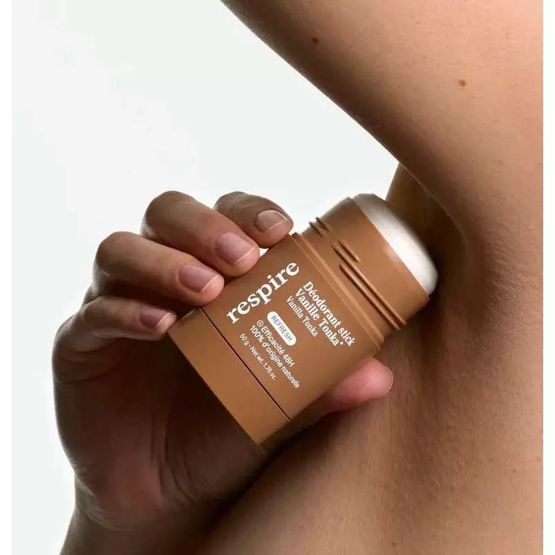 Personne appliquant le déodorant stick Vanille Tonka de Respire sous le bras.