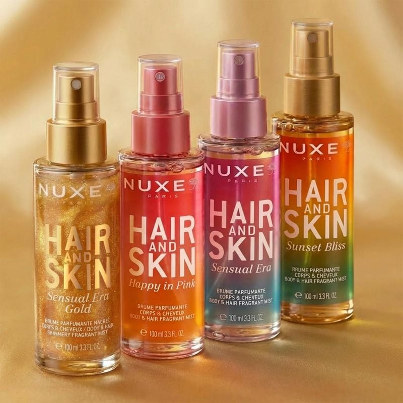 Cadre élégant avec la brume parfumée NUXE Sensual Era Gold et des paillettes dorées.