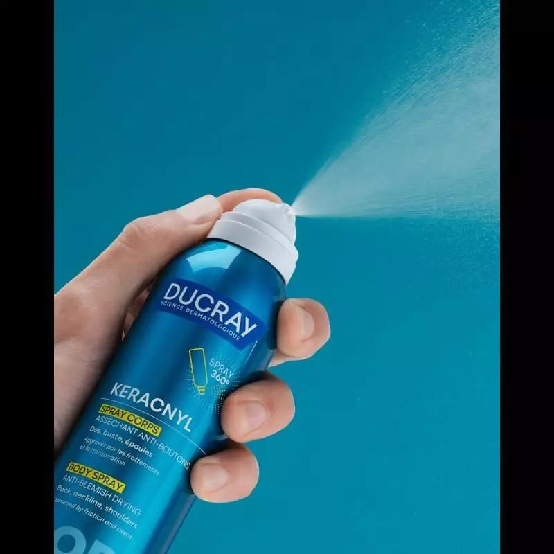 Spray corporel Ducray Keracnyl dans une salle de bain moderne avec serviettes