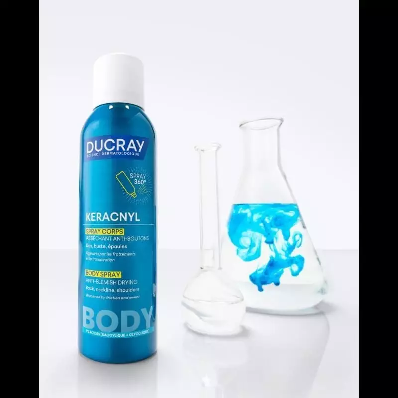 Spray corporel Ducray Keracnyl posé sur une étagère dans la salle de bain