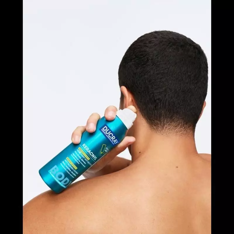Femme appliquant le spray corps Ducray Keracnyl sur son dos dans un cadre de vie