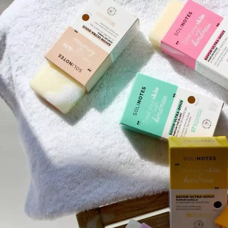 Savon solide Solinotes 1985896 posé sur un porte-savon en bois à côté d'une serviette blanche dans u