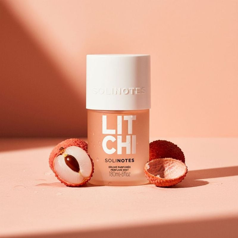Flacon de brume parfumée Solinotes Litchi sur bois avec litchis et fleurs roses, soulignant son parf
