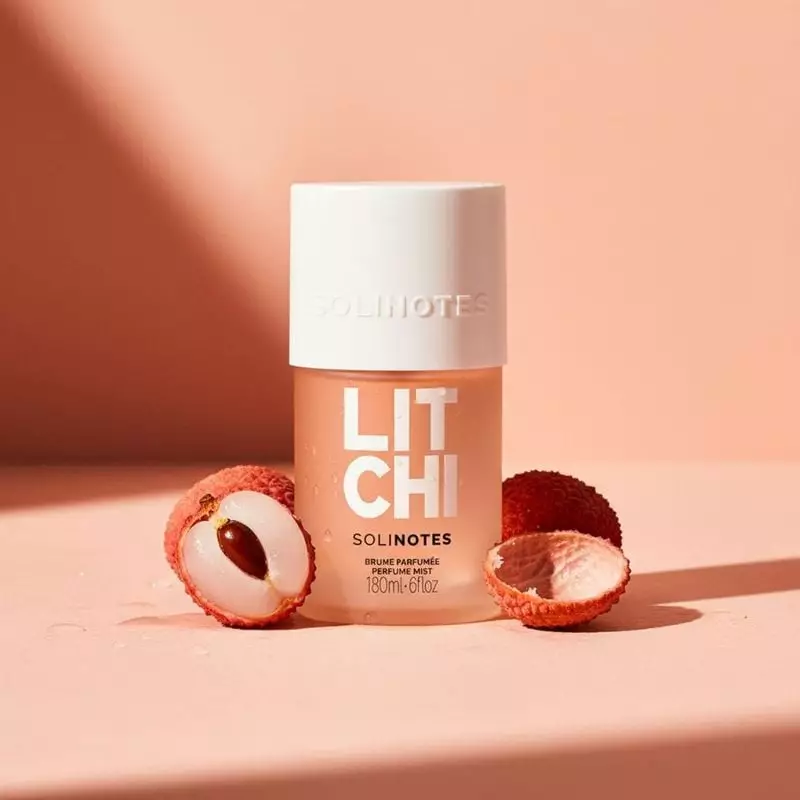 Flacon de brume parfumée Solinotes Litchi sur bois avec litchis et fleurs roses, soulignant son parf