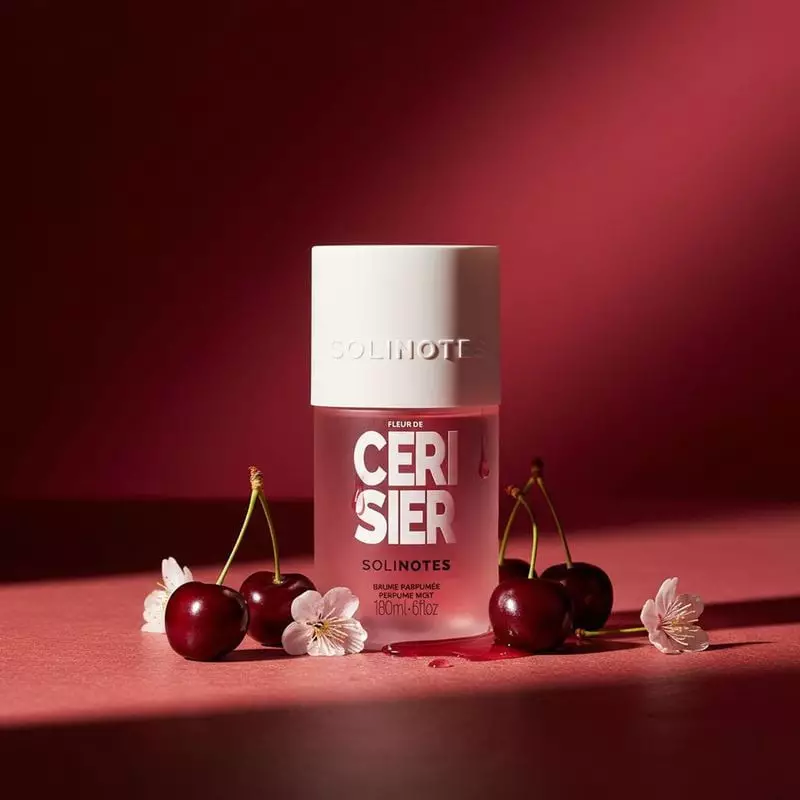 Image d'ambiance de la brume Fleur de Cerisier Solinotes à côté d'une écharpe en soie et de cerises 