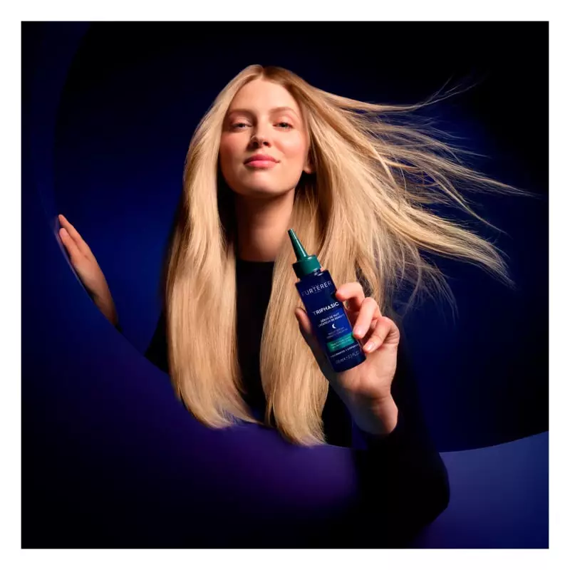 Image lifestyle d'une femme appliquant le sérum René Furterer 1990166 sur son cuir chevelu avant de 