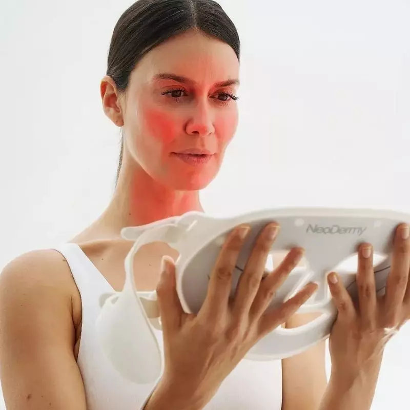 Femme portant le masque LED NeoDermy 1990162 pour un traitement de photothérapie à domicile, démontr