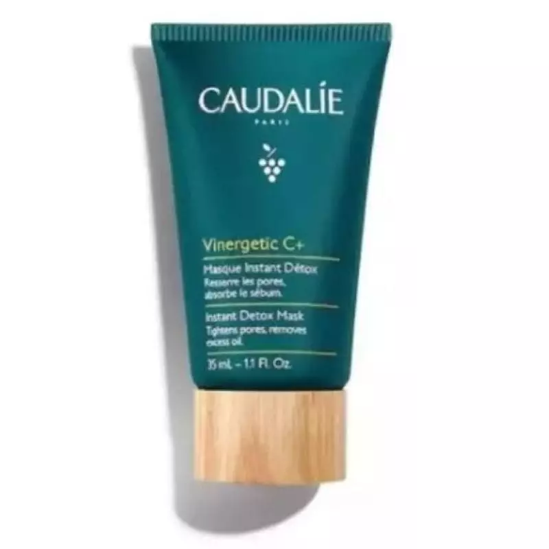 Gros plan sur la texture rose crémeuse du Masque Instant Détox de Caudalie appliqué sur la peau.