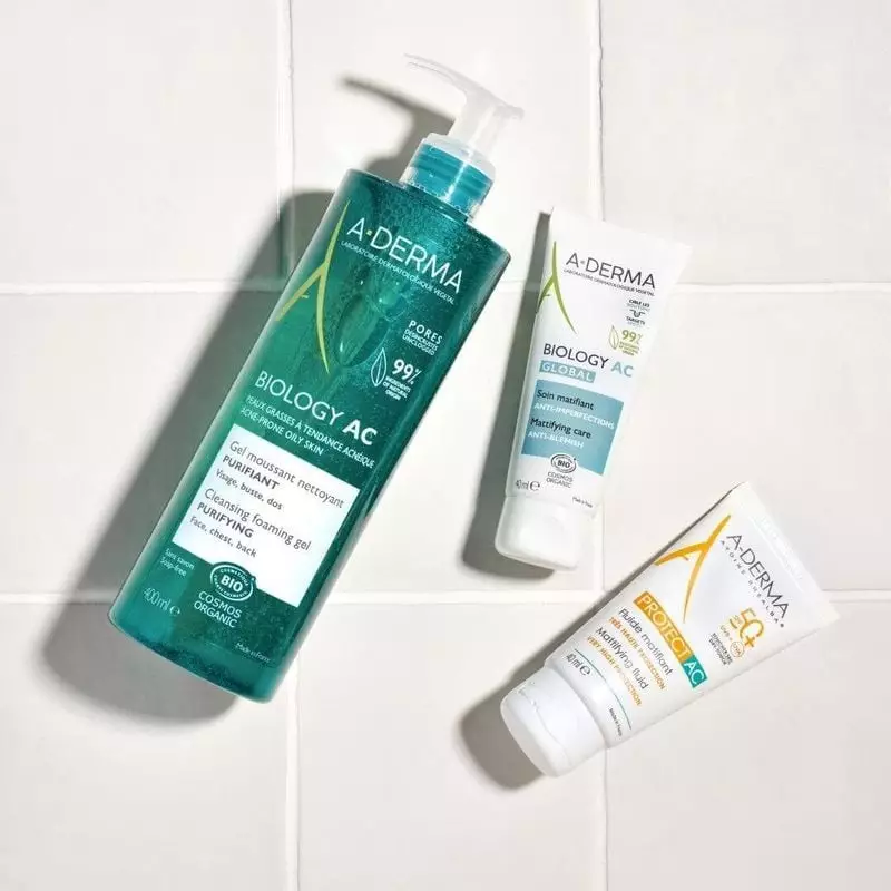 Tube de soin A-Derma Biology AC Global posé sur un comptoir de salle de bain avec lumière naturelle,