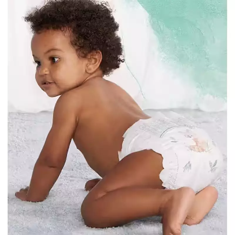 Bébé heureux dormant paisiblement dans une couche Pampers Harmonie Taille 4