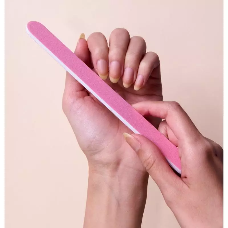 Main utilisant une lime à ongles Mylar Vitry 2067651 pour façonner un ongle naturel, avec un bout ar