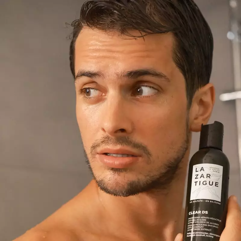 Image lifestyle d'une personne aux cheveux sains utilisant le shampoing Lazartigue Clear DS dans une